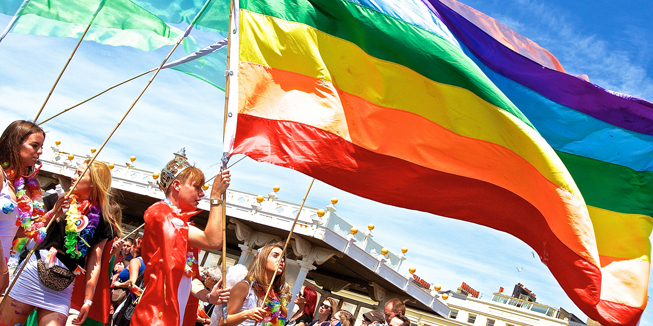 Homo: Foto van bezoekers van de Brighton Pride met een regenboogvlag.