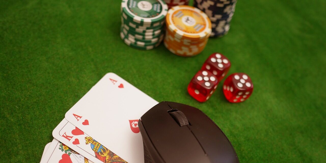 Een pokertafel met daarop een aantal pokerschijfjes, dobbelstenen, kaarten en een computermuis