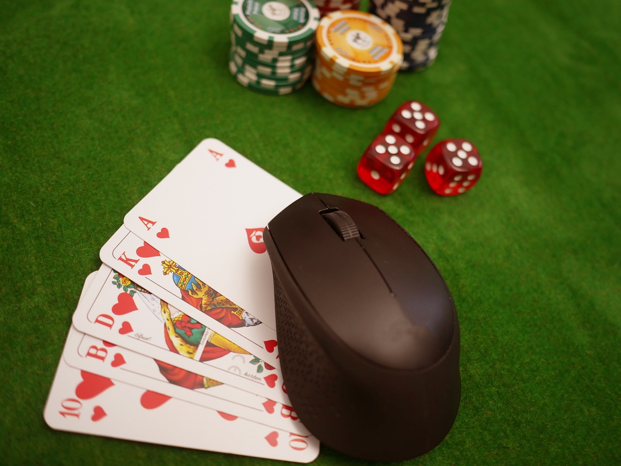 Een pokertafel met daarop een aantal pokerschijfjes, dobbelstenen, kaarten en een computermuis
